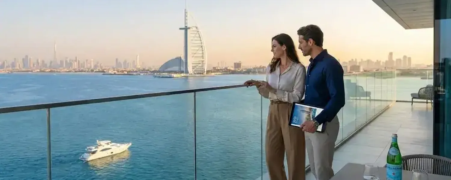 Real estate agent and buyer discussing Dubai property purchase with Burj Al Arab and waterfront skyline view